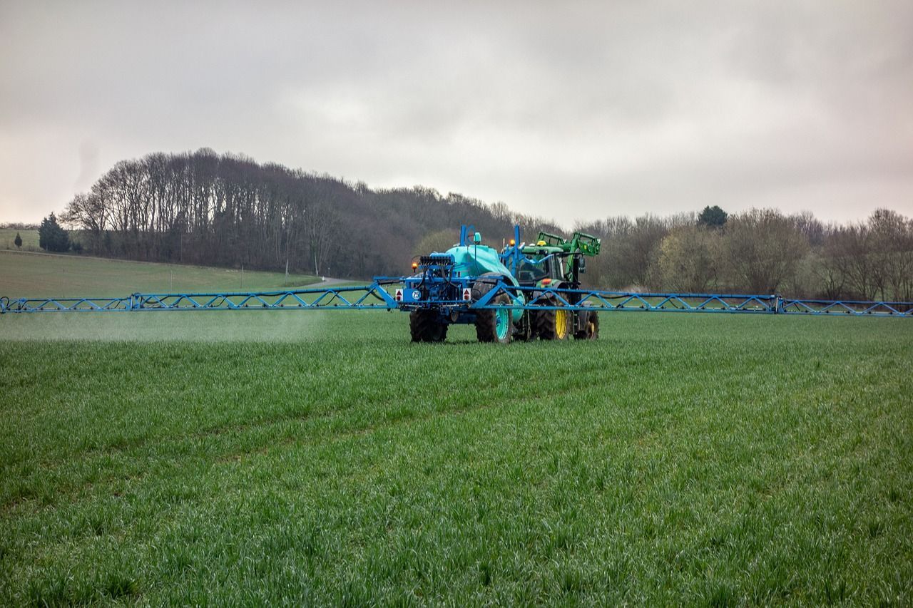 Tractor esparciendo fertilizante en cultivo-kunak