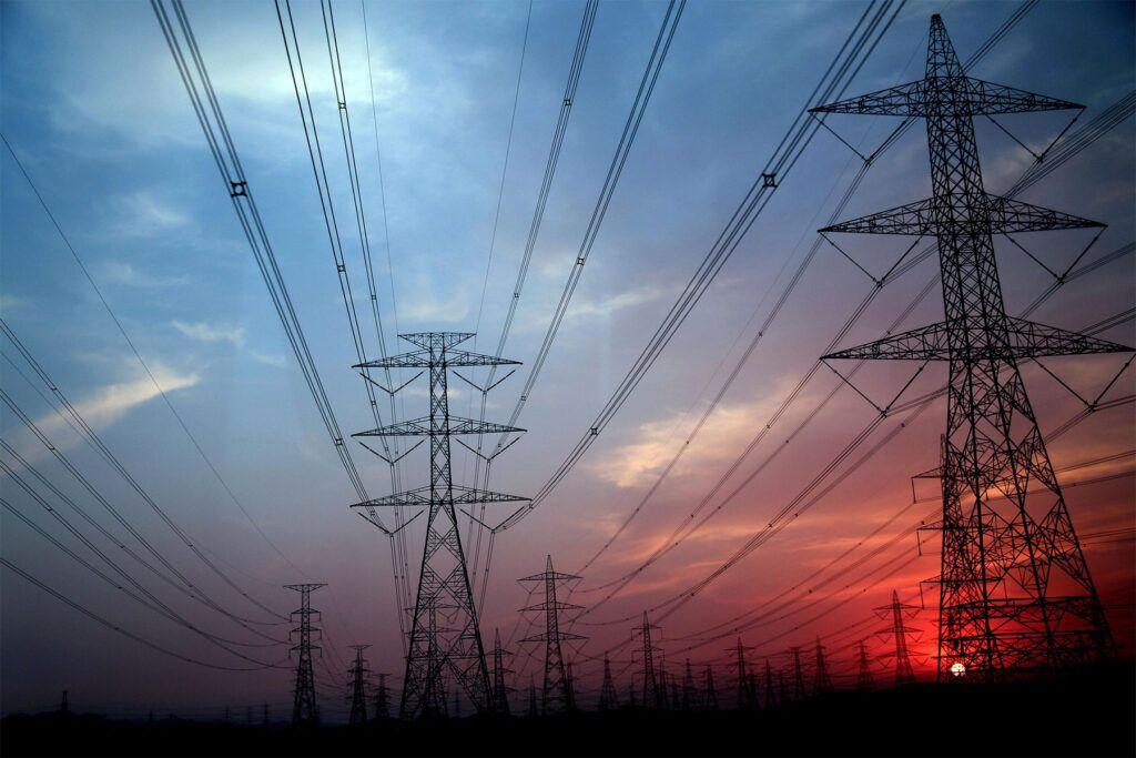 High-voltage power lines at sunset, symbolising the energy infrastructure and its environmental impact. - Kunak